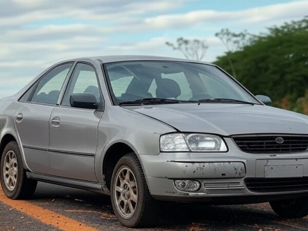 Acidente de carro na BR-153 em Goiás, veículo danificado na rodovia, paisagem rural do cerrado, sem pessoas.